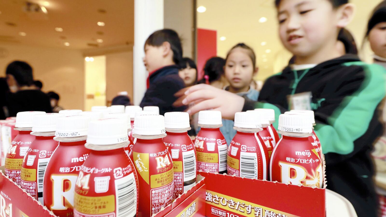 Children look at some products manufactured at the Meiji Moriya Factory in Moriya, Japan. Photo by Taku Yaginuma for the Japan News-Yomiuri