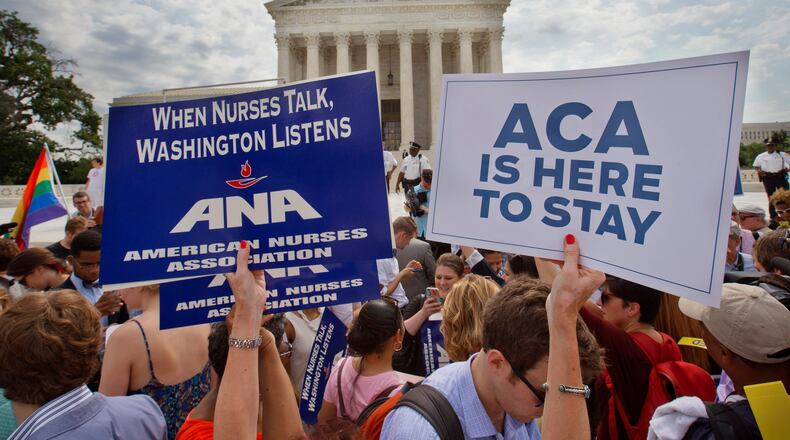 Supporters of the Affordable Care Act hold up signs as the opinion for health care is reported outside of the Supreme Court in Washington, Thursday June 25, 2015. The Supreme Court on Thursday upheld the nationwide tax subsidies under President Barack Obama's health care overhaul, in a ruling that preserves health insurance for millions of Americans. The justices said in a 6-3 ruling that the subsidies that 8.7 million people currently receive to make insurance affordable do not depend on where they live, under the 2010 health care law. (AP Photo/Jacquelyn Martin)