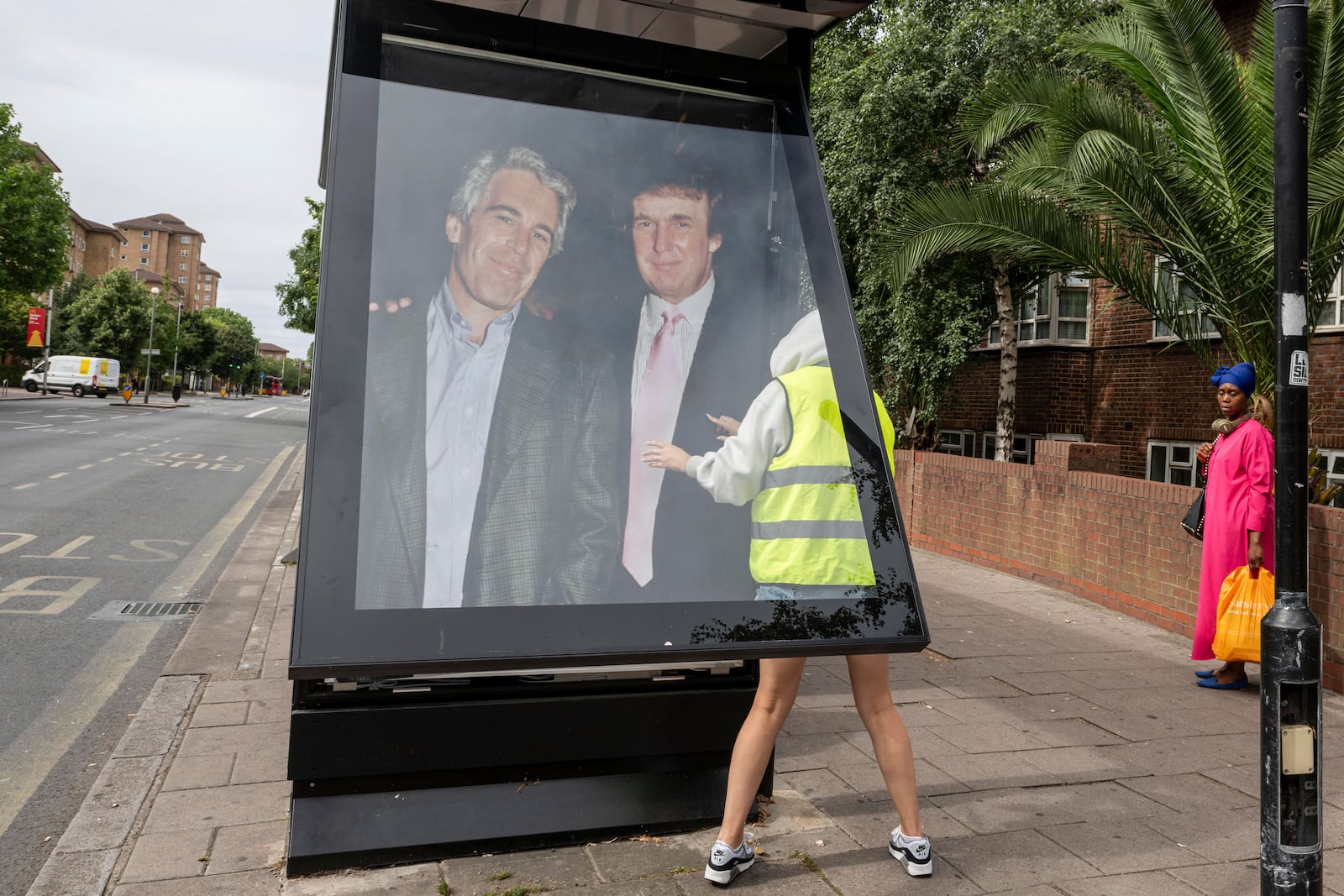 Activists put up a poster showing President Donald Trump and Jeffrey Epstein near the U.S. Embassy in London, Thursday, July 17, 2025.(AP Photo/Thomas Krych)