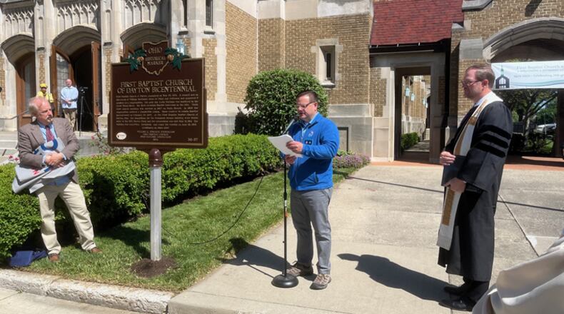 William Kennedy, center, of the Ohio History Connection reads the text of the newly installed historical marker commemorating the bicentennial of the First Baptist Church of Dayton after services on Sunday, May 12, 2024. At right is lead pastor, the Rev. Kent Berghuis. ED RICHTER/STAFF