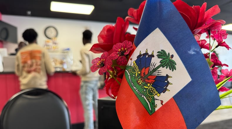 Haitian flags are displayed on all the tables at Rose Goute Creole Restaurant in Springfield Friday, Feb. 21, 2025. BILL LACKEY/STAFF