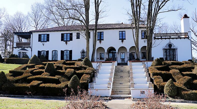 The 6-bedroom home with about about 5,600 sq. ft. of living space. is highlighted by a maze of boxwood gardens surrounding cascading waterfalls that flank a staircase to the circular driveway. The drive curves around the garden and waterfalls, leveling at the covered formal front entry, which has a row of arches and earth-tone flooring. CONTRIBUTED PHOTO BY KATHY TYLER