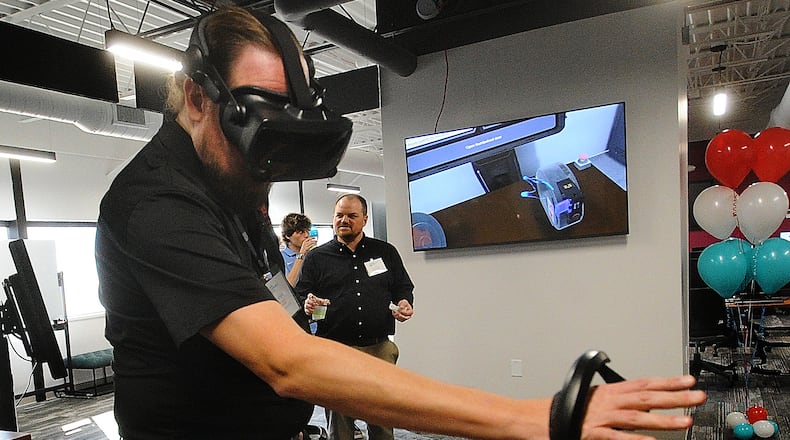 Josh Latham, demonstrates virtual reality training at the new University of Dayton Research Institute, Digital Transformation Center (DTC) Wednesday, Nov. 8, 2023. MARSHALL GORBY\STAFF