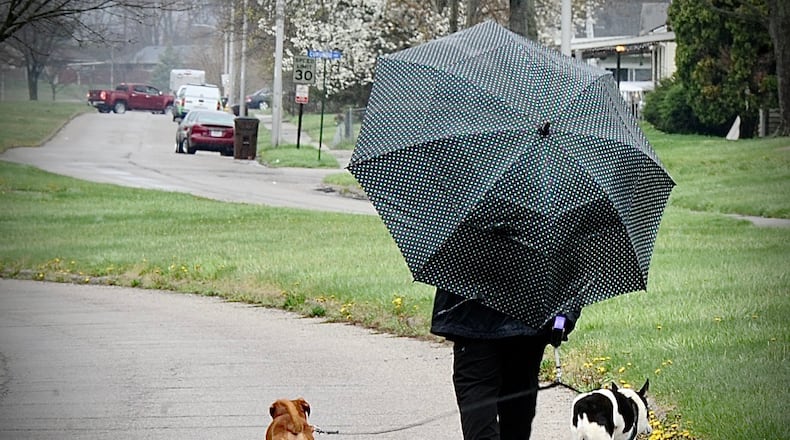 FILE PHOTO: You can expect a lot of dog gone rain Wednesday April 13, 2022. Keep your umbrella handy like this lady in Trotwood walking her dogs on Brumbaugh Boulevard. MARSHALL GORBY \STAFF