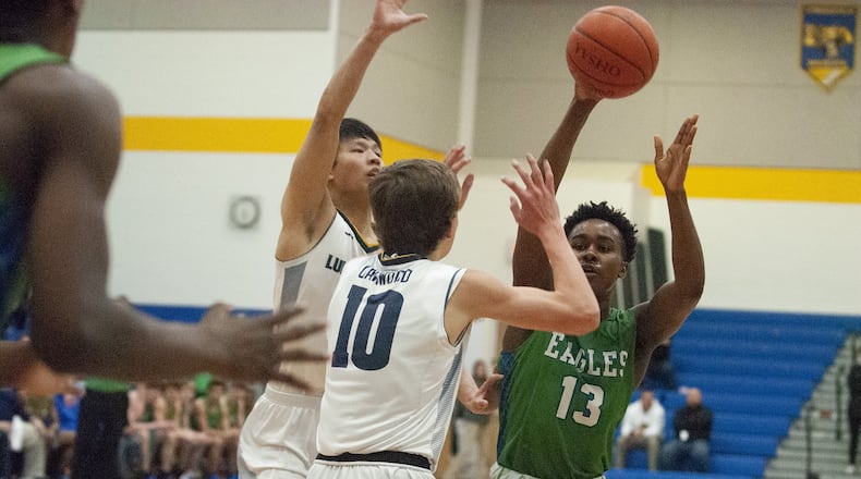 Chaminade Julienne’s Brandon Gibson passes over Oakwood’s Jack Epley (10) and Daniel Hu in the first half of Wednesday night’s Division II sectional semifinal at Springfield High School. Jeff Gilbert/CONTRIBUTED