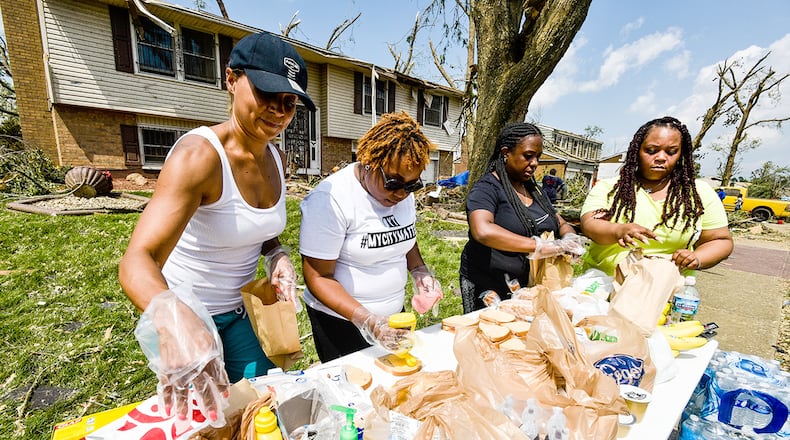 Left to right: Michelle Farris, Ashley Browning, Ashley Stephens and Ashley Corporal, with volunteer group SoLoved set up a table on Olive Tree Drive in Trotwood to helps serve food and water to those in need in the area Tuesday, May 28 after overnight tornadoes ripped through the region. NICK GRAHAM/STAFF