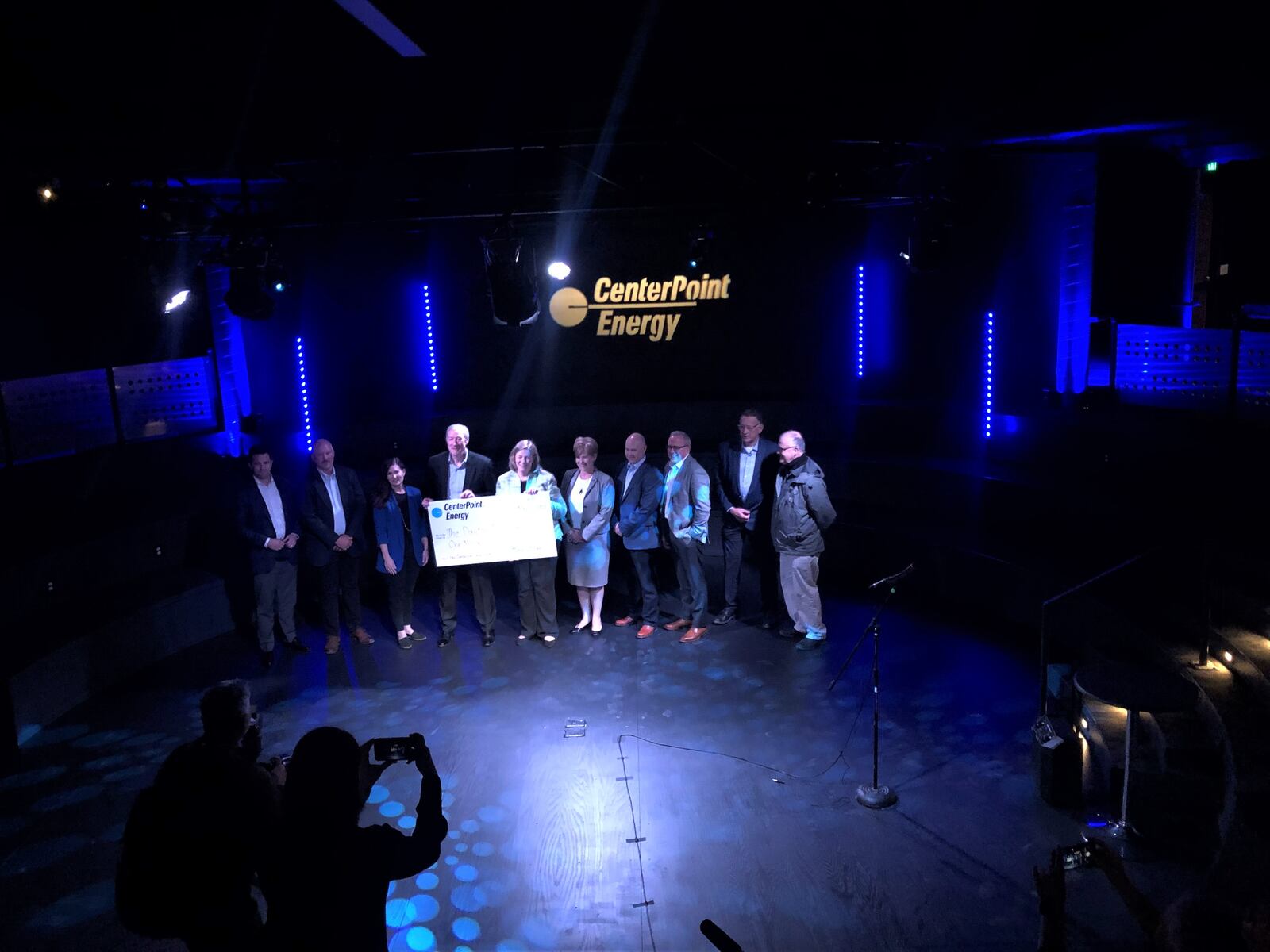 Dayton Mayor Nan Whaley and CenterPoint Energy CEO David Lesar hold a large $1 million cardboard check. CenterPoint donated $1 million to help create the theater in the round event space in the basement of the Dayton Arcade. CORNELIUS FROLIK / STAFF