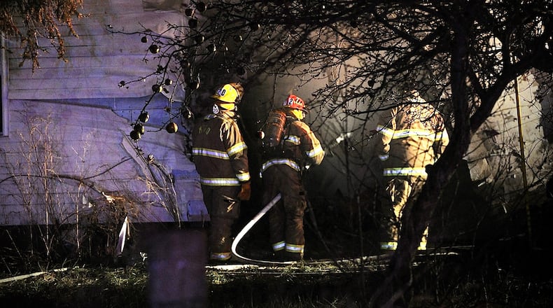 One person is dead after a car crashed into a house and both caught fire Wednesday evening, Dec. 8, 2021, in the 9900 block of state Route 235 in Champaign County on the border with Logan County. MARSHALL GORBY/STAFF