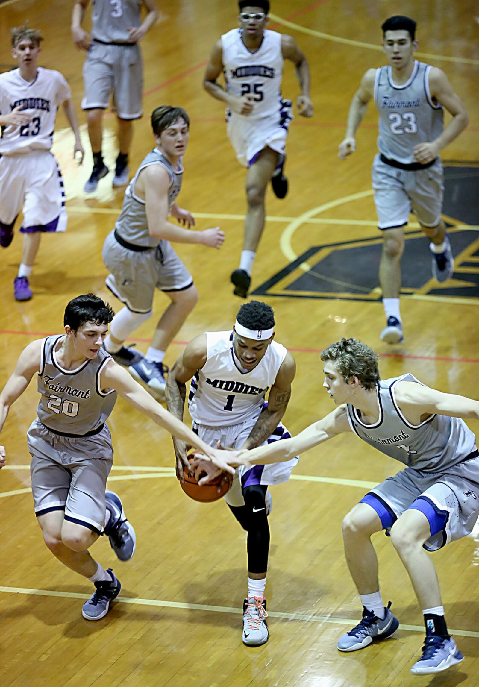 Fairmont’s Kamron Drollet (20) and Kellan Bochenek (2) try to halt Middletown guard Nelson Rutledge’s break to the hoop during Wednesday night’s game at Wade E. Miller Gym in Middletown. CONTRIBUTED PHOTO BY E.L. HUBBARD