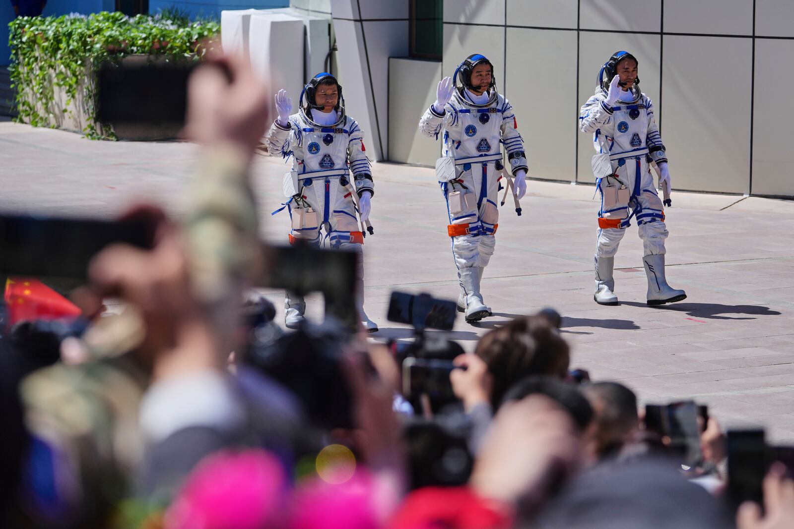 Chinese astronauts for the Shenzhou 20 mission, from right, Chen Zhongrui, Chen Dong and Wang Jie wave as they attend a send-off ceremony for their manned space mission at the Jiuquan Satellite Launch Center in northwestern China, Thursday, April 24, 2025. (AP Photo/Andy Wong)