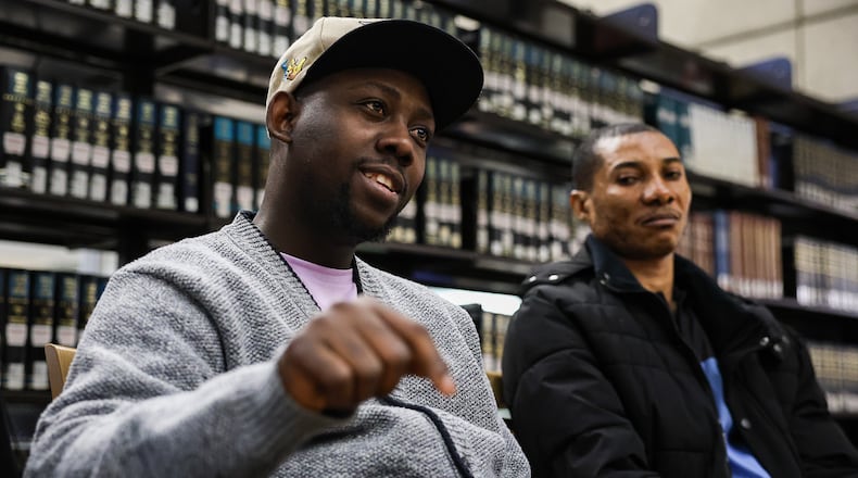 Wesley Joseph (left) talks during an interview at Sinclair Community College on March 28 while Jean Roma Barthelemy (right) listens. Joseph, a Haitian immigrant, is one of thousands who have come to Ohio in recent years. He said gangs in the country have threatened any migrants who return. BRYANT BILLING / STAFF