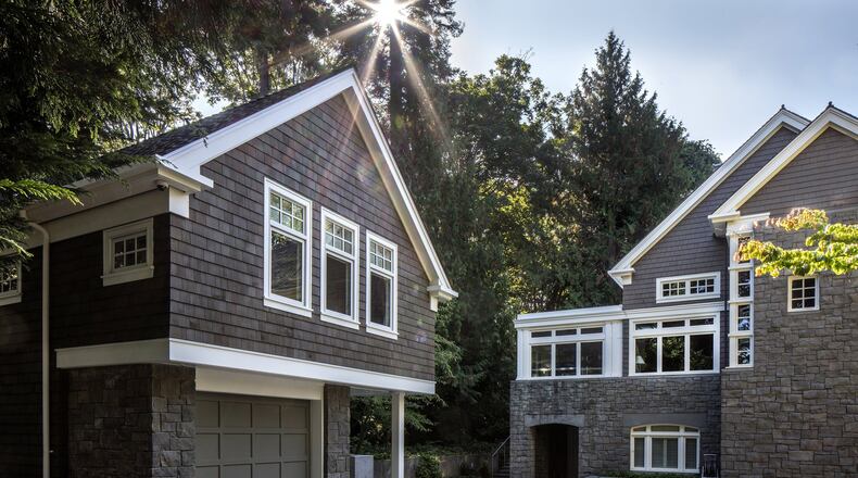The bluestone patio was existing, says architect Tyler Engle, but everything to the west of it pervious concrete and pavers is new. While Kevin and Carolyn s guesthouse, left, mimics the main home, We used three windows in the front, instead of a pair. (Steve Ringman/Seattle Times/MBR)