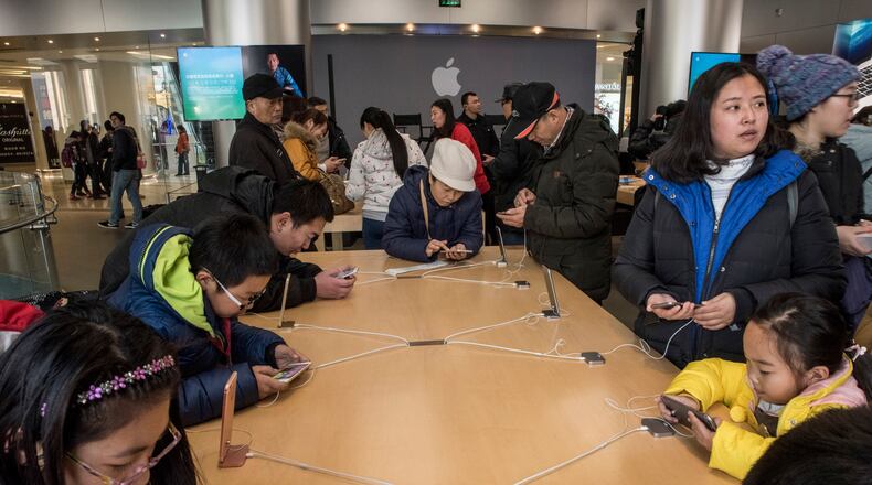 Visitors check out the iPhone 6s at an Apple store in Beijing in late 2015. China’s Foxconn plant in Zhengzhou, which makes about half of all iPhones, produces 500,000 a day, or roughly 350 a minute. (Gilles Sabrie/The New York Times)