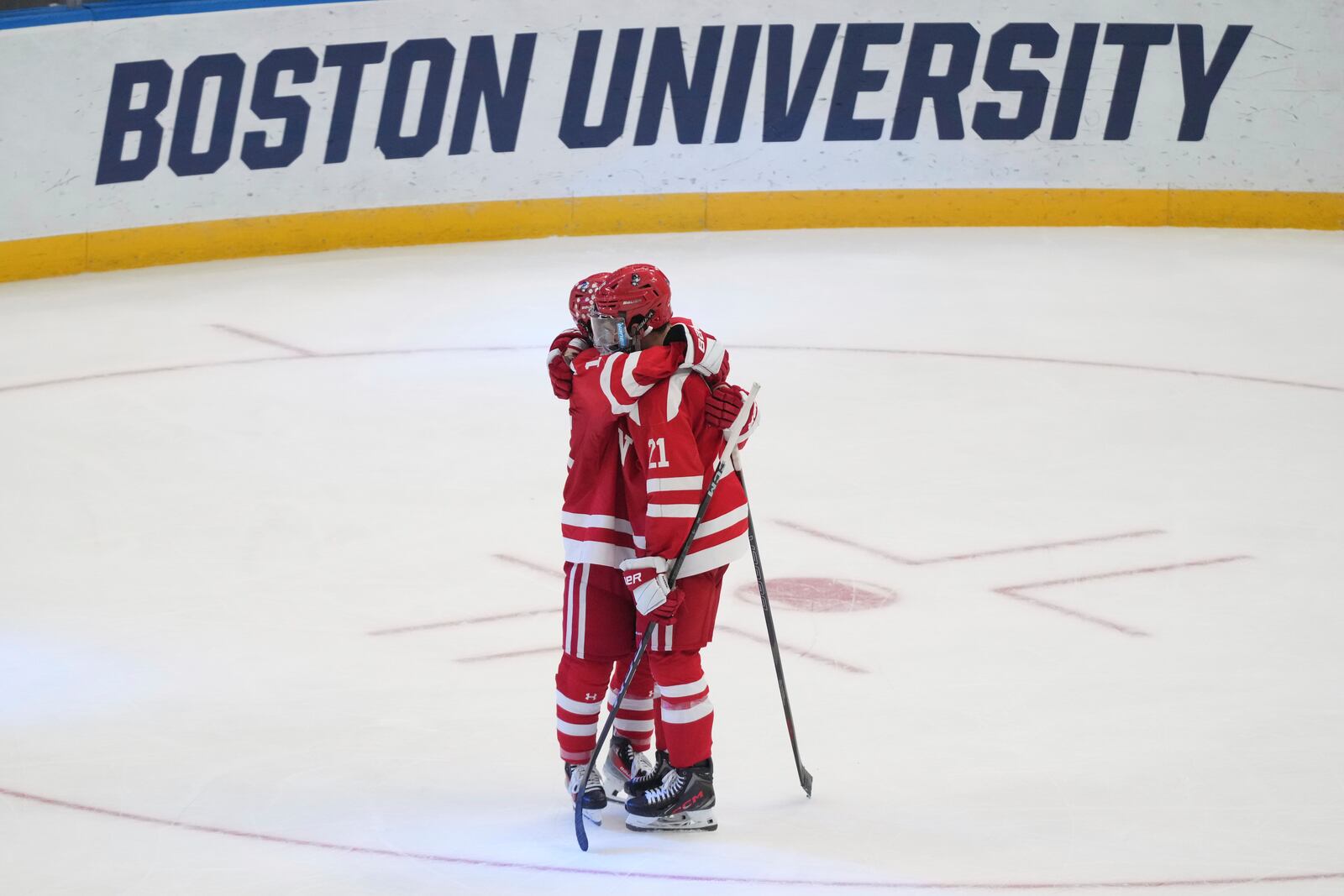 Boston University's Devin Kaplan (21) and Matt Copponi hug after being defeated by Western Michigan in the championship game of the NCAA Frozen Four men's college hockey tournament, Saturday, April 12, 2025, in St. Louis (AP Photo/Jeff Roberson)