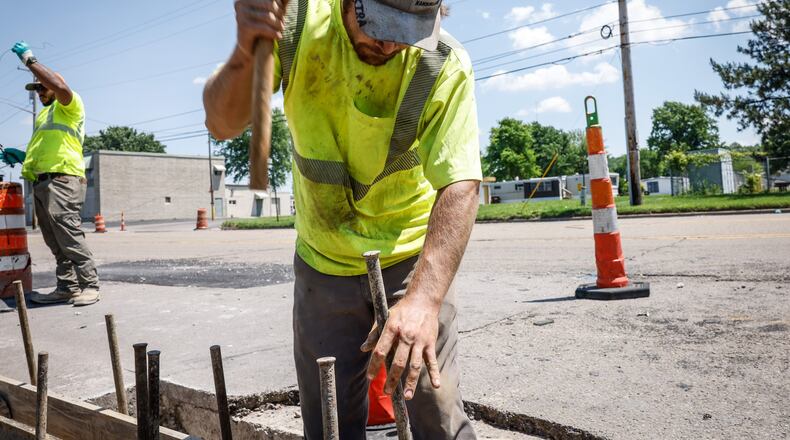 Jimmy Whealdon, center, and Eligah Swift, both Oglesby Construction employees, set curbside forms on Dryden Road near East River Road in Moraine Tuesday May 31, 2022. The construction on Dryden Road between the Great Miami River and Kreitzer Road is a $1.4 million project that is part of more than $3 million in road improvements scheduled to take place this year and in 2023 and 2026. JIM NOELKER/STAFF