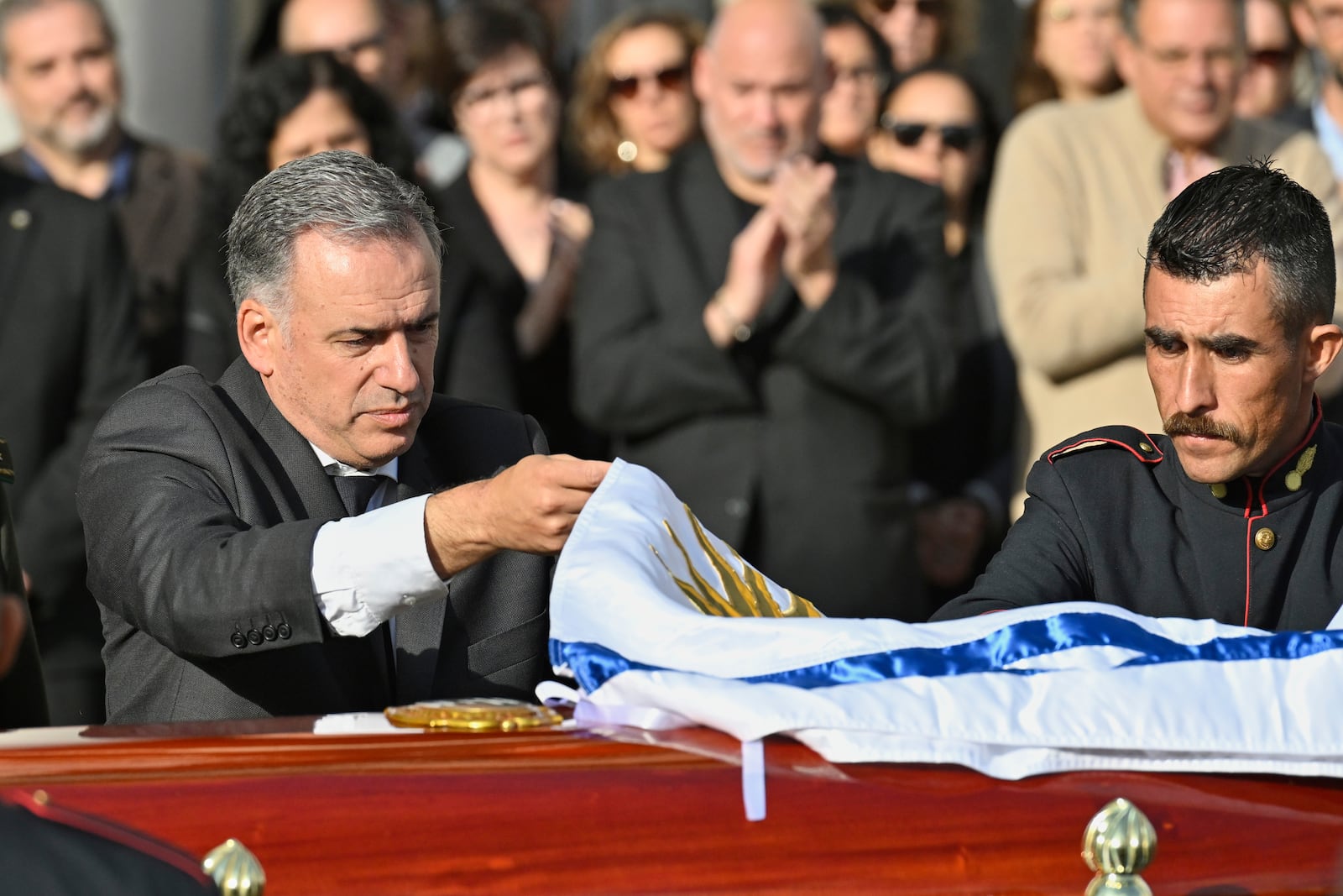 Uruguayan President Yamandu Orsi covers the casket of the late, former Uruguayan President Jose Mujica with the national flag at the presidential palace in Montevideo, Uruguay, Wednesday, May 14, 2025. (AP Photo/Santiago Mazzarovich)