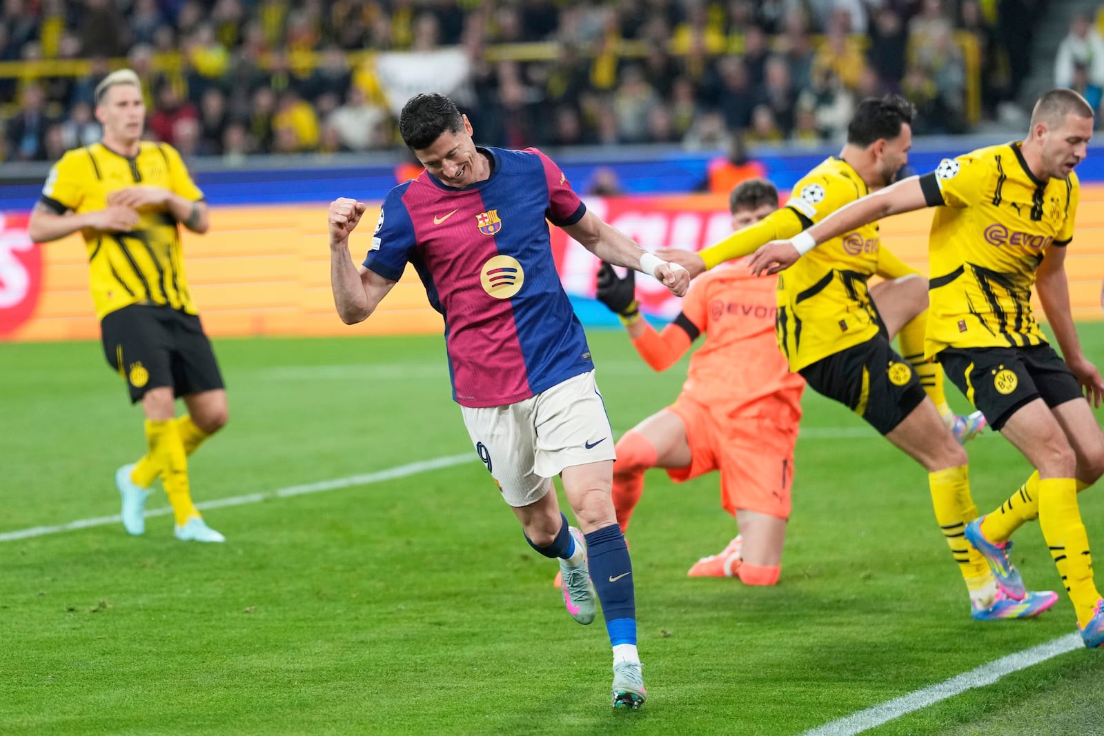 Barcelona's Robert Lewandowski celebrates after forcing an own goal by Dortmund's Ramy Bensebaini during the Champions League quarterfinals second leg soccer match between Borussia Dortmund and Barcelona, at the Signa-Iduna Park in Dortmund, Germany, Tuesday, April 15, 2025. (AP Photo/Matthias Schrader)