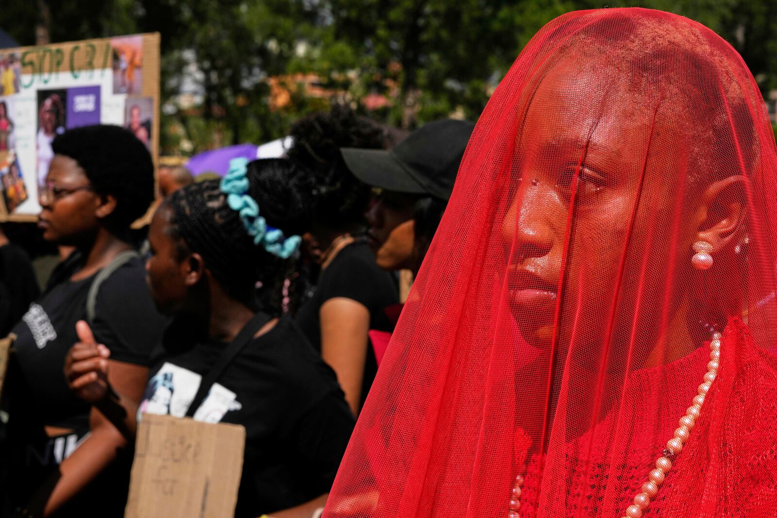 Activist Karabo Khumo dressed in red dress cover-up in a veil as "Lady Justice" during the women's protest and hand over of a petition demanding that gender-based violence and femicide be declared a national disaster, at the Union Buildings in Pretoria, South Africa, Friday, April 11, 2025. (AP Photo/Themba Hadebe)