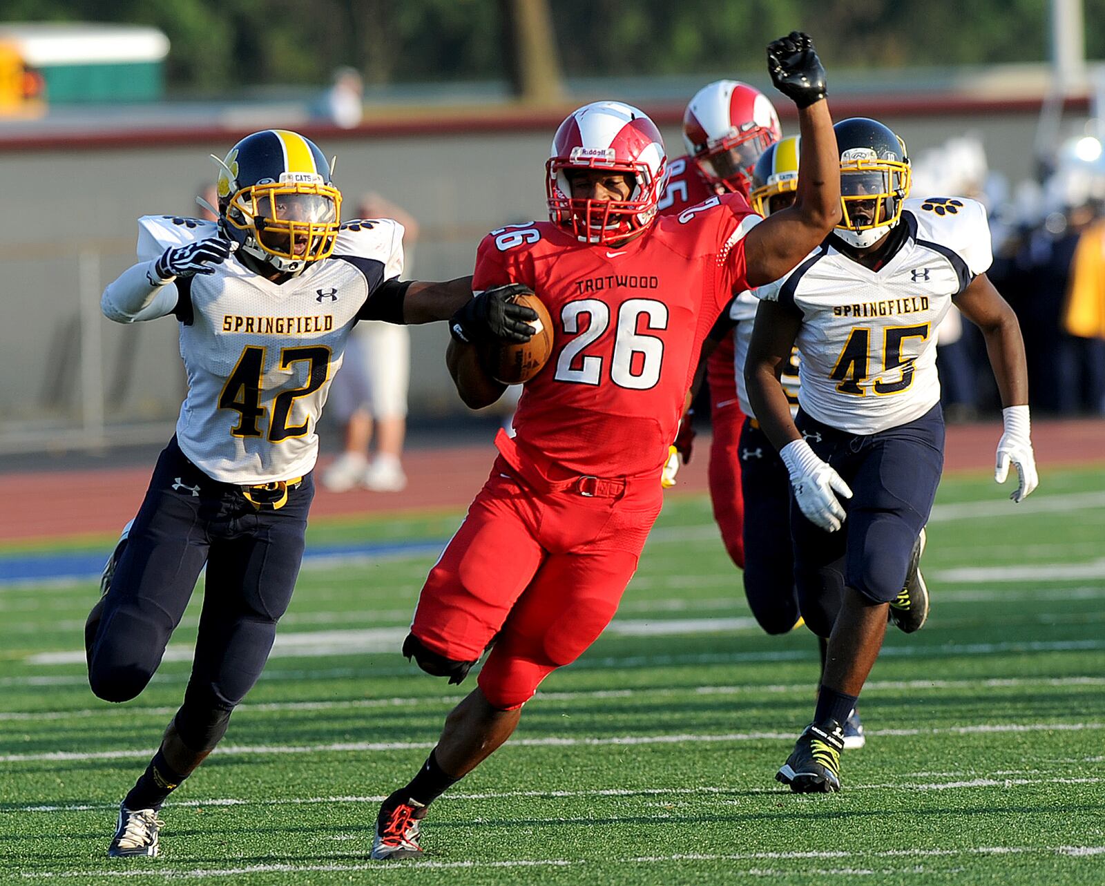 Trotwood's Ashton Jackson, 26, looks for room to run with Springfield's Kawambee Moss, 42, in pursuit Friday night at Welcome Stadium. MARSHALL GORBY / STAFF