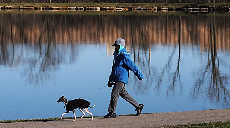 Sue Tackett walks her dog, Hobbs, around Delco Park in Kettering on a February morning. MARSHALL GORBY / STAFF