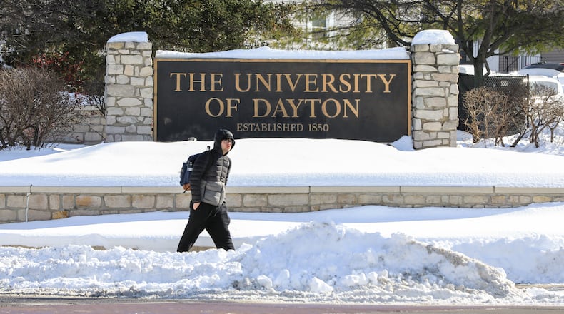 A man walks by a University of Dayton sign at the intersection of East Stewart Street and Brown Street on Tuesday, Jan. 28 in Dayton. BRYANT BILLING/STAFF