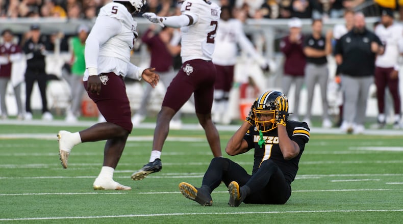Missouri wide receiver Donovan Olugbode (1) grabs his helmet after missing a fourth-down reception as Texas A&M defensive tackle DJ Hicks (5) and cornerback Dezz Ricks (2) celebrate during the first half an NCAA college football game Saturday, Nov. 8, 2025, in Columbia, Mo. (AP Photo/L.G. Patterson)