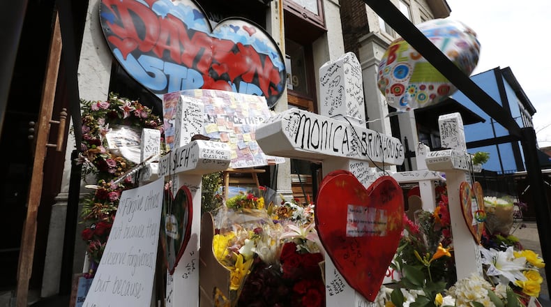 Memorials to victims of the mass shooting on August 4 have begun to shrink in the Oregon District and some business owners would like to have them removed. Many people continued to visit the memorials during the Friday lunch hour. TY GREENLEES / STAFF