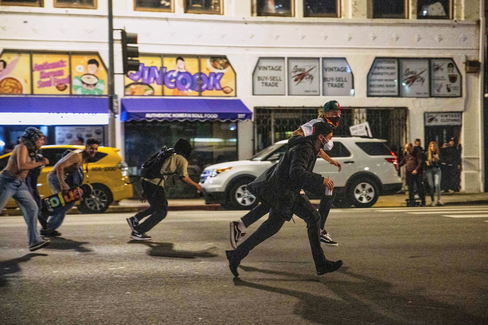 Protestors run to avoid being kettled by police during protests over the Trump administration's immigration raids in Los Angeles, Monday, June 9, 2025. (AP Photo/Ethan Swope)