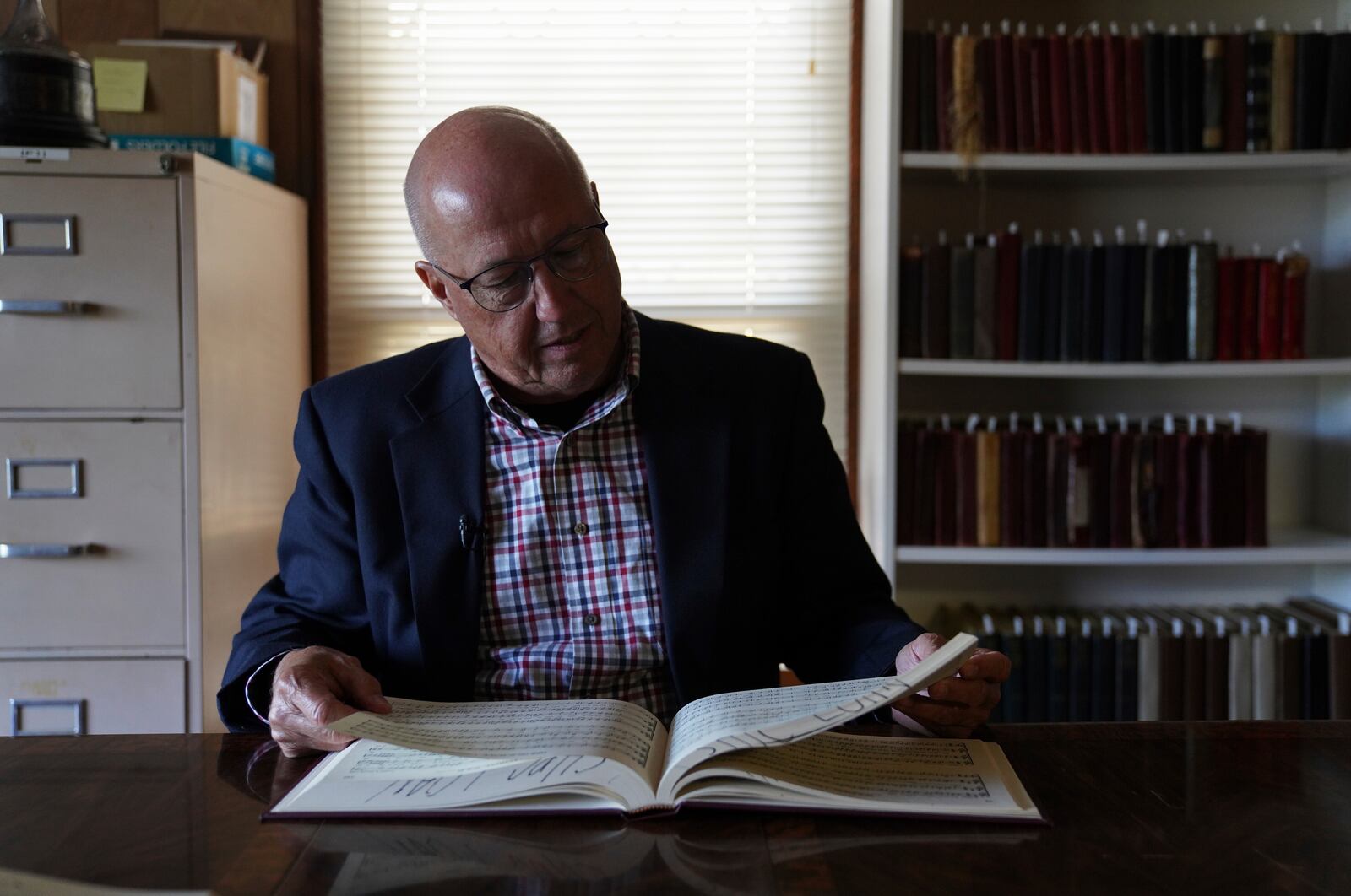 David Ivey, a longtime singer and chair of the Sacred Harp Publishing Company's revision and music committee, looks through "The Sacred Harp," shape-note songbook at the Sacred Harp Publishing Company and Museum in Carrollton, Ga., on Friday, March 21, 2025. (AP Photo/Jessie Wardarski)