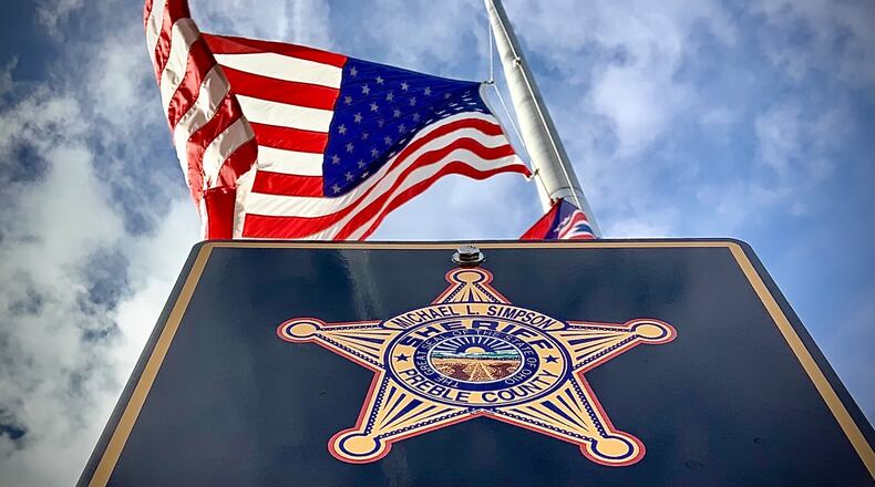 The American flag flies at half staff over the Preble County Sheriff's Office Monday, Dec. 18, 2018, after Deputy Joshua Hamilton was killed in an early morning head-on crash in his cruiser on state Route 503 between Gratis and West Alexandria. MARSHALL GORBY\STAFF