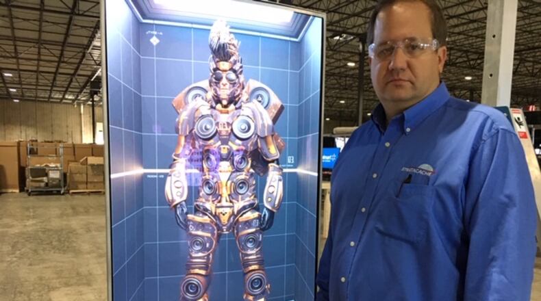 Chris Riegel, founder and chief executive of Dayton-based Stratacache, with one of the company’s digital monitors, assembled at the company’s Trotwood facility. THOMAS GNAU/FILE