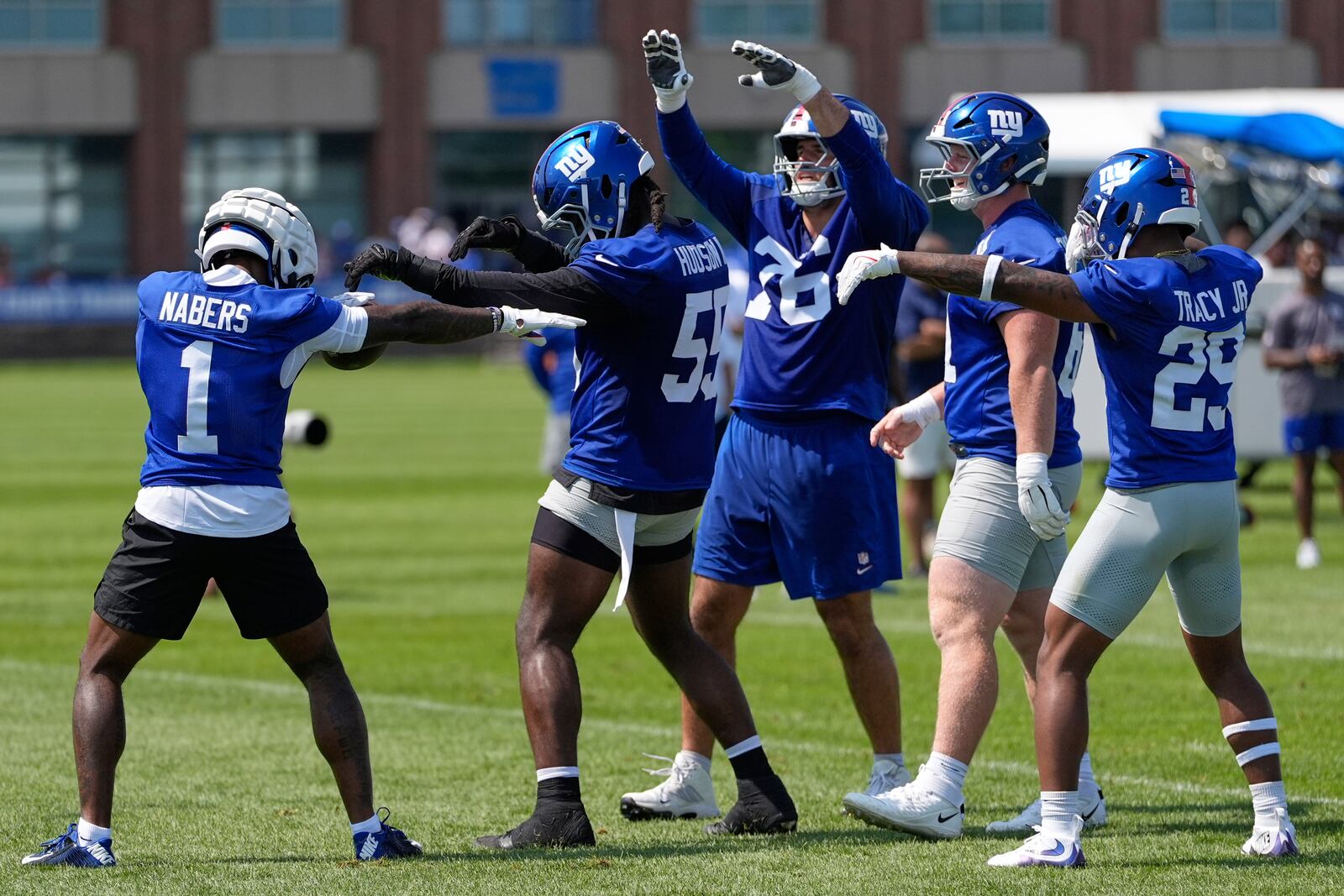 New York Giants' Malik Nabers (1), left, celebrates with teammates after a touchdown during a practice at the team's NFL football training camp in East Rutherford, N.J., Thursday, July 24, 2025. (AP Photo/Seth Wenig)