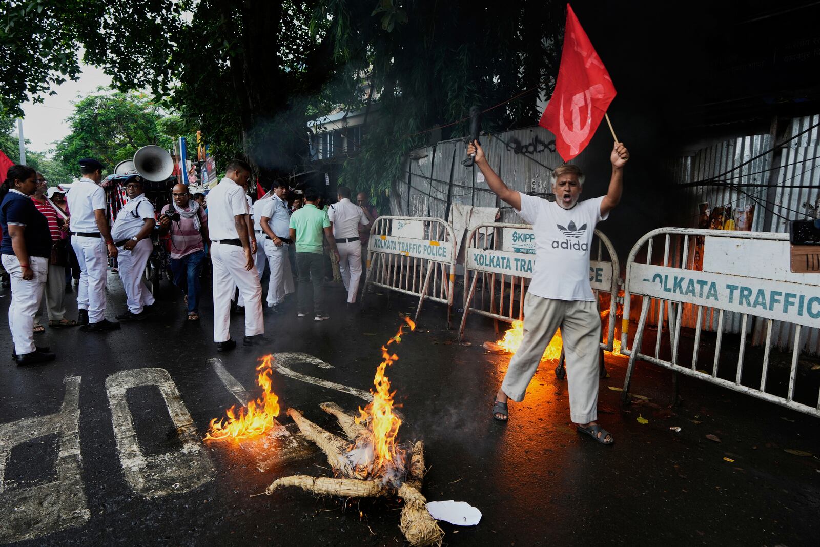 A supporter of Centre of India Trade Unions, CITU, shouts slogans as an effigy of Indian Prime Minister burns during a nation-wide strike to protest what they call the anti-labor and anti-poor policies of the federal government, in Kolkata, India, Wednesday, July 9, 2025. (AP Photo/Bikas Das)