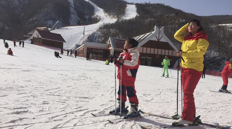 A mother and her daughter take a rest on the slopes at the Masik Pass ski resort in North Korea Sunday, Jan. 28, 2018. The ski resort, built in 2013 at the order of North Korean leader Kim Jong Un, is to be the site of joint training for North and South Korean skiers ahead of the Pyeongchang Olympics. (AP Photo/Eric Talmadge)