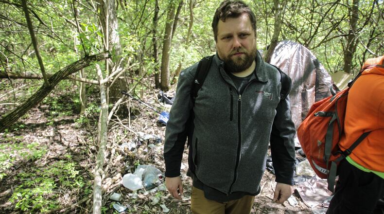 Louie Wood Jr., and other homeless men, head out of the woods were they have tents setup. All the men fear they may contract coronavirus. JIM NOEKLER/STAFF