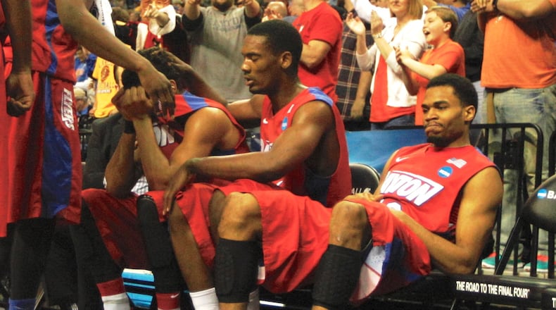 Dayton's Devin Oliver, center, hides his tears as Dyshawn Pierre consoles him and Vee Sanford, far right, looks on as the final seconds tick away in a loss to Florida in the South Regional final on Saturday, March 29, 2014, at FedExForum in Memphis, Tenn. David Jablonski/Staff