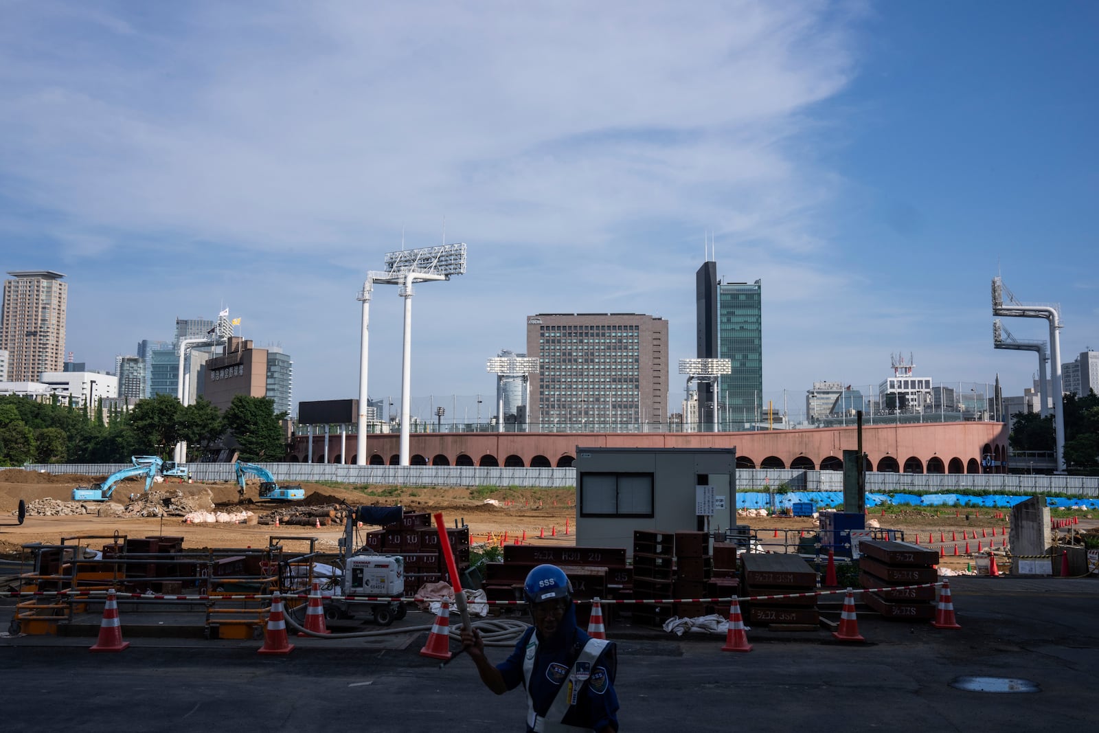 Workers at a construction site near the Jingu stadium in Tokyo, Monday, June 30, 2025. (AP Photo/Louise Delmotte)