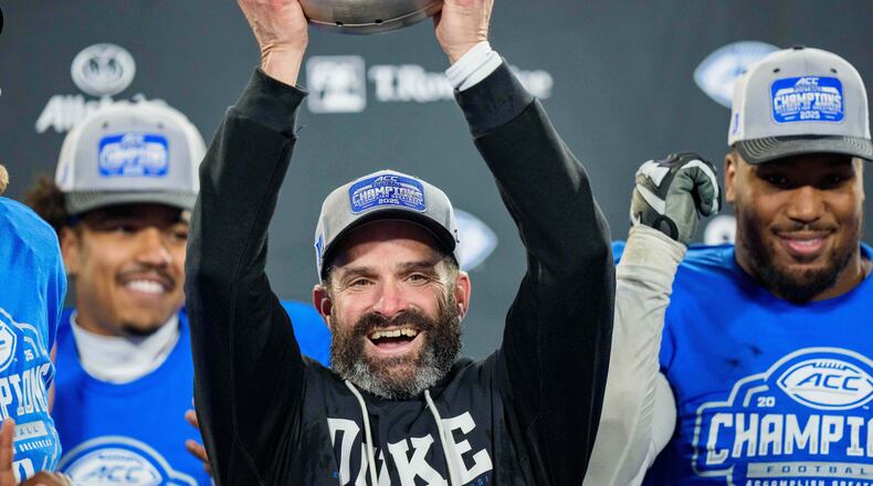 Duke head coach Manny Diaz holds up the trophy after defeating Virginia in the Atlantic Coast Conference championship NCAA college football game Saturday, Dec. 6, 2025, in Charlotte, N.C. (AP Photo/Jacob Kupferman)