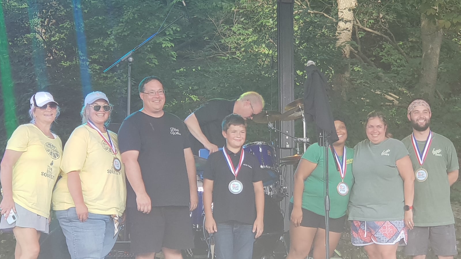 The winners of the 2025 Springfield Gourmet Food Truck Competition pose on stage. From left to right, the winners include Raging Bull Woodfired Pizza in yellow, Black Willow in black, Home Cooked Vibes in light green and Iggy Ragu's in dark green. CONTRIBUTED