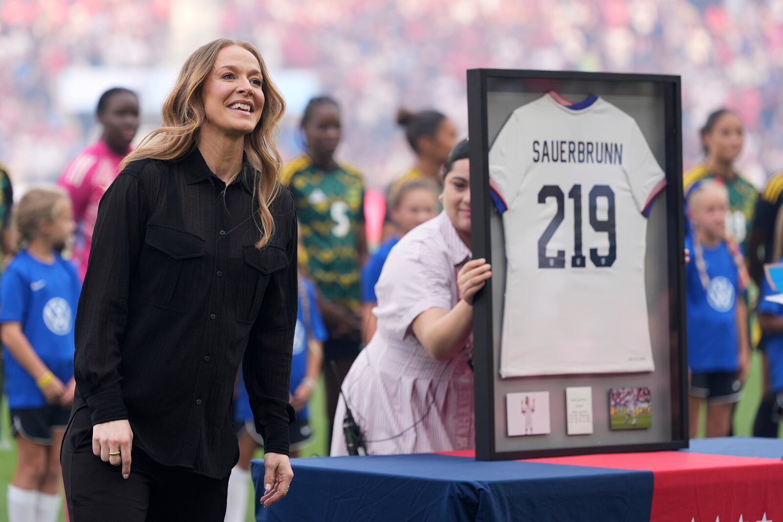 Longtime defender Becky Sauerbrunn, a St. Louis native who retired from soccer late last year, is honored before the start of an international friendly soccer match between the United States and Jamaica Tuesday, June 3, 2025, in St. Louis. (AP Photo/Jeff Roberson)