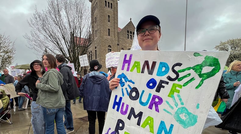 Sign carrying protesters lined the sidewalks around the Greene County Courthouse Saturday afternoon at one of the "Hands Off 2025" rallies held across the country to voice opposition to Trump Administration policies. Hundreds of demonstrators stood through a steady rain for more than an hour at the rally, one of two held in U.S. Congressional District 10. Photo by Jan Underwood.