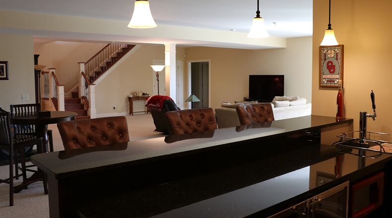 Finished with Berber carpet, 5-inch baseboards and recessed ceiling lights, the open recreation area has plenty of space for game tables. The wet bar boasts custom cabinets, a commercial refrigerator, a dishwasher, sink, granite countertops and a TV mount.