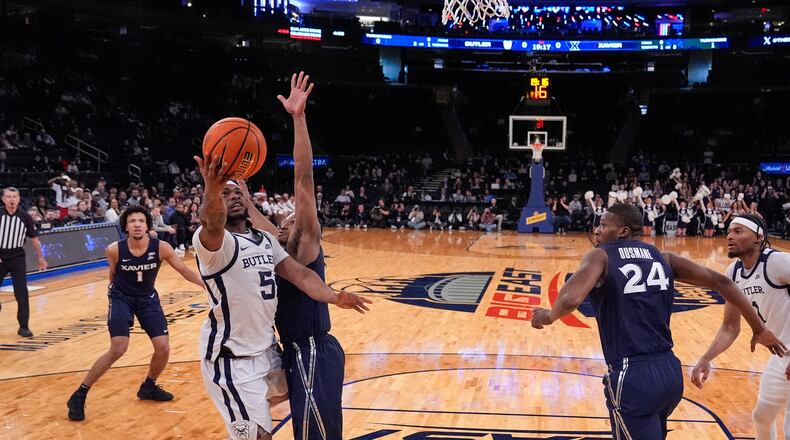 Butler's Posh Alexander (5) drives past Xavier's Quincy Olivari as Abou Ousmane (24) watches during the first half of an NCAA college basketball game in the first round of the Big East basketball tournament, Wednesday, March 13, 2024, in New York. (AP Photo/Frank Franklin II)