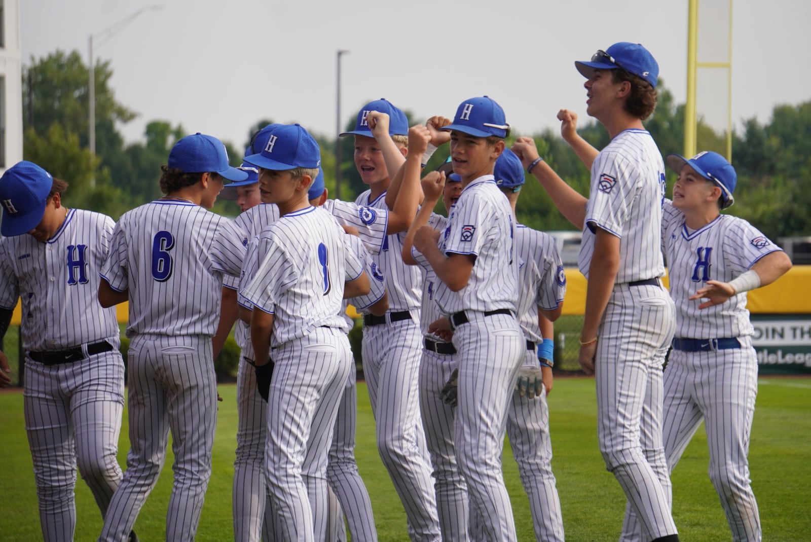 West Side Little League players break a huddle before their Great Lakes Region game against Kentucky on Saturday at the Little League Central Region Complex in Whitestown, Indiana. West Side won 7-0. CHRIS VOGT / CONTRIBUTED