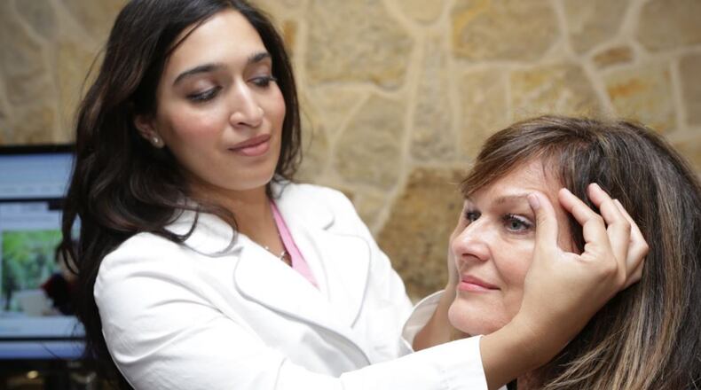 Dr. Amina Husain, eye surgeon with Premier Eye Surgeons, examines a patient.
