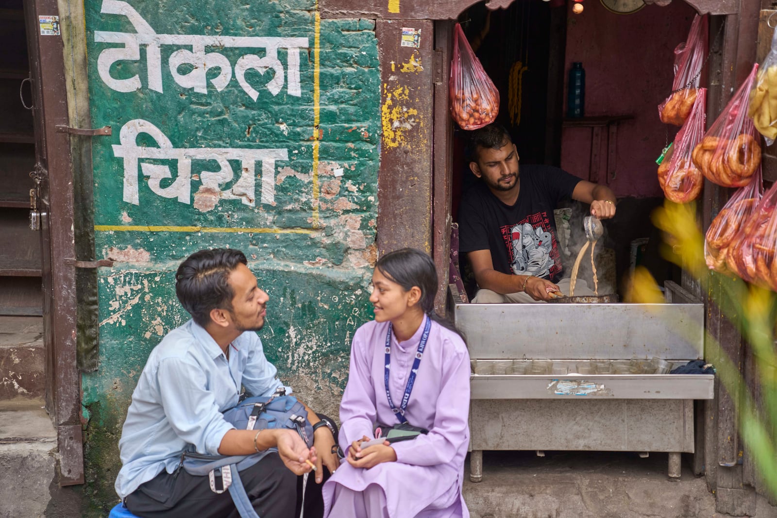 A couple talks sitting outside a tea shop at Basantapur Durbar square in Kathmandu, Nepal, Wednesday, July 23, 2025. (AP Photo/Niranjan Shrestha)