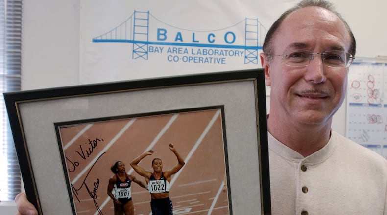 FILE - BALCO founder Victor Conte holds up an autographed photo addressed to Conte of track star Marion Jones in his office in Burlingame, Calif., Oct. 21, 2003. (AP Photo/Paul Sakuma, File)