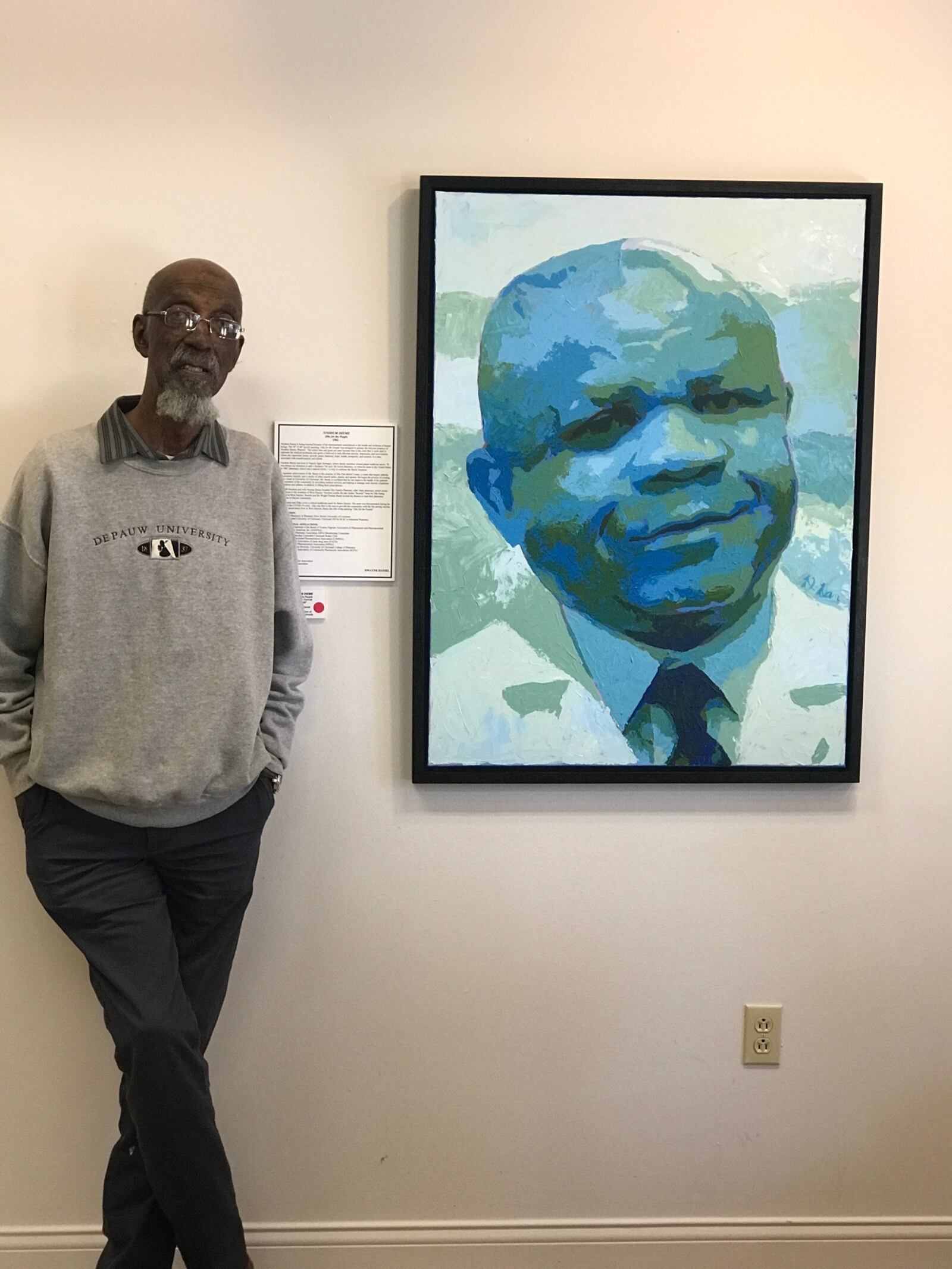 Artist Bing Davis at his EbonNia Gallery standing next to Dayton Skyscraper piece “Ziks For The People” done by artist Dwayne Daniel. Tom Archdeacon/CONTRIBUTED
