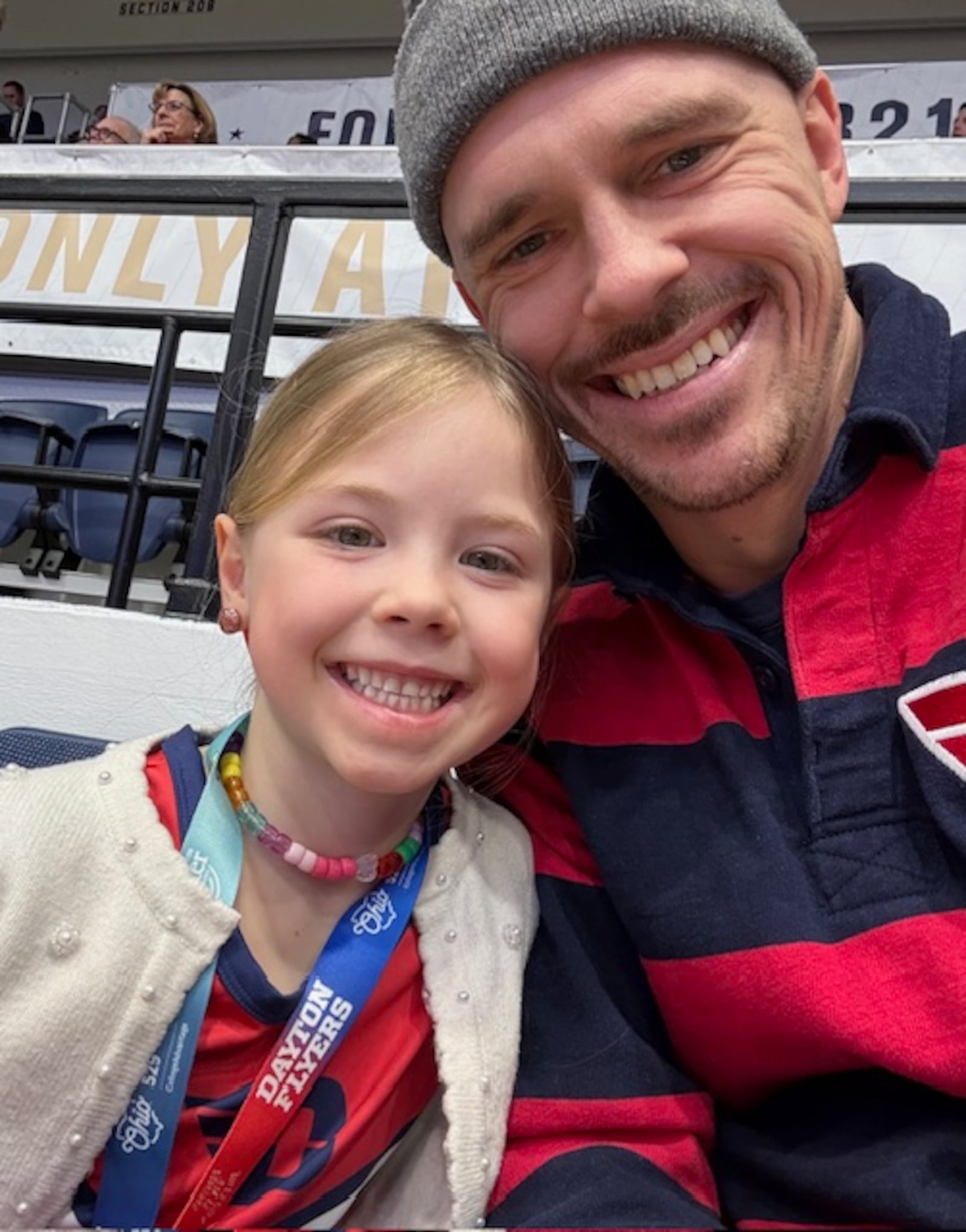 Dayton fans Matilda Trick, left, and her dad Matthew Trick pose for a photo during a game against George Washington on Friday, Feb. 27, 2026, at the Charles E. Smith Center in Washington, D.C. Contributed photo