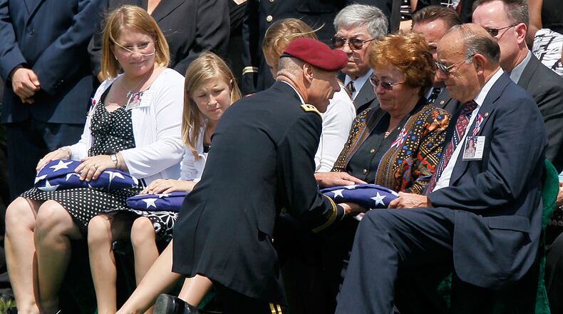 ARLINGTON, VA - JUNE 07: Lieutenant General Frank Helmick (3rd L), Commander of XVIII Airborne Corps, presents a flag to Sharon (4th L) and Donald Belkofer (R), parents of Army Lieutenant Colonel Thomas Belkofer of the 10th Mountain Division at Ft. Drum, New York, as Belkofer's wife Margaret (L) and daughter Ashley (2nd L) look on during his funeral June 7, 2010 at Arlington National Cemetery in Arlington, Virginia. Belkofer was killed in a Taliban attack on a NATO convoy on May 18, 2010 in Kabul, Afghanistan. (Photo by Alex Wong/Getty Images)